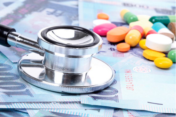 Stethoscope and prescription medications on pile of money